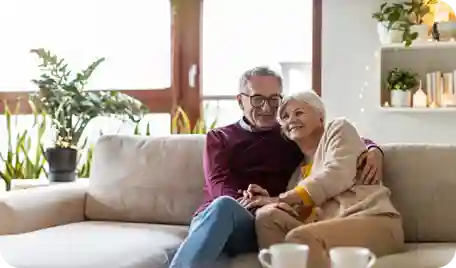A senior couple contentedly sitting on a couch together